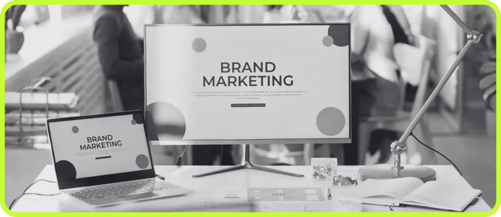 Workspace with laptop and desktop showing “Brand Marketing” — Astrella’s branding system in action